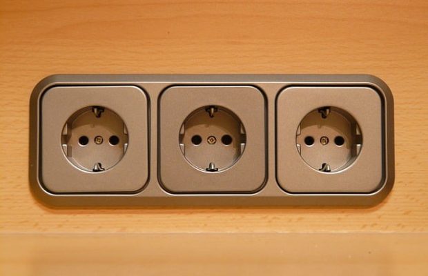Bloc de trois prises électriques encastrées dans mur en bois